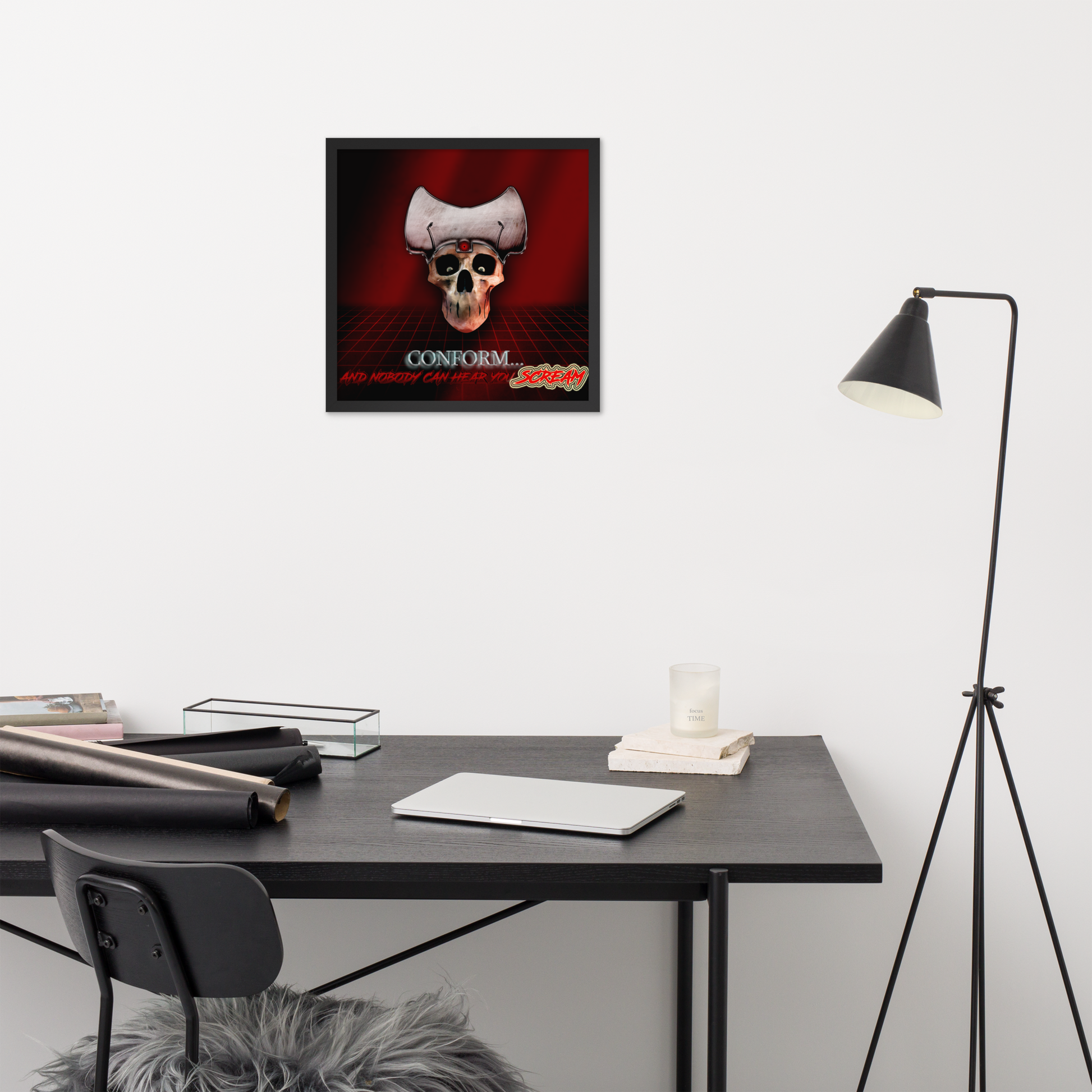 Framed poster with heavy metal skull design on a wall above a desk with office supplies.