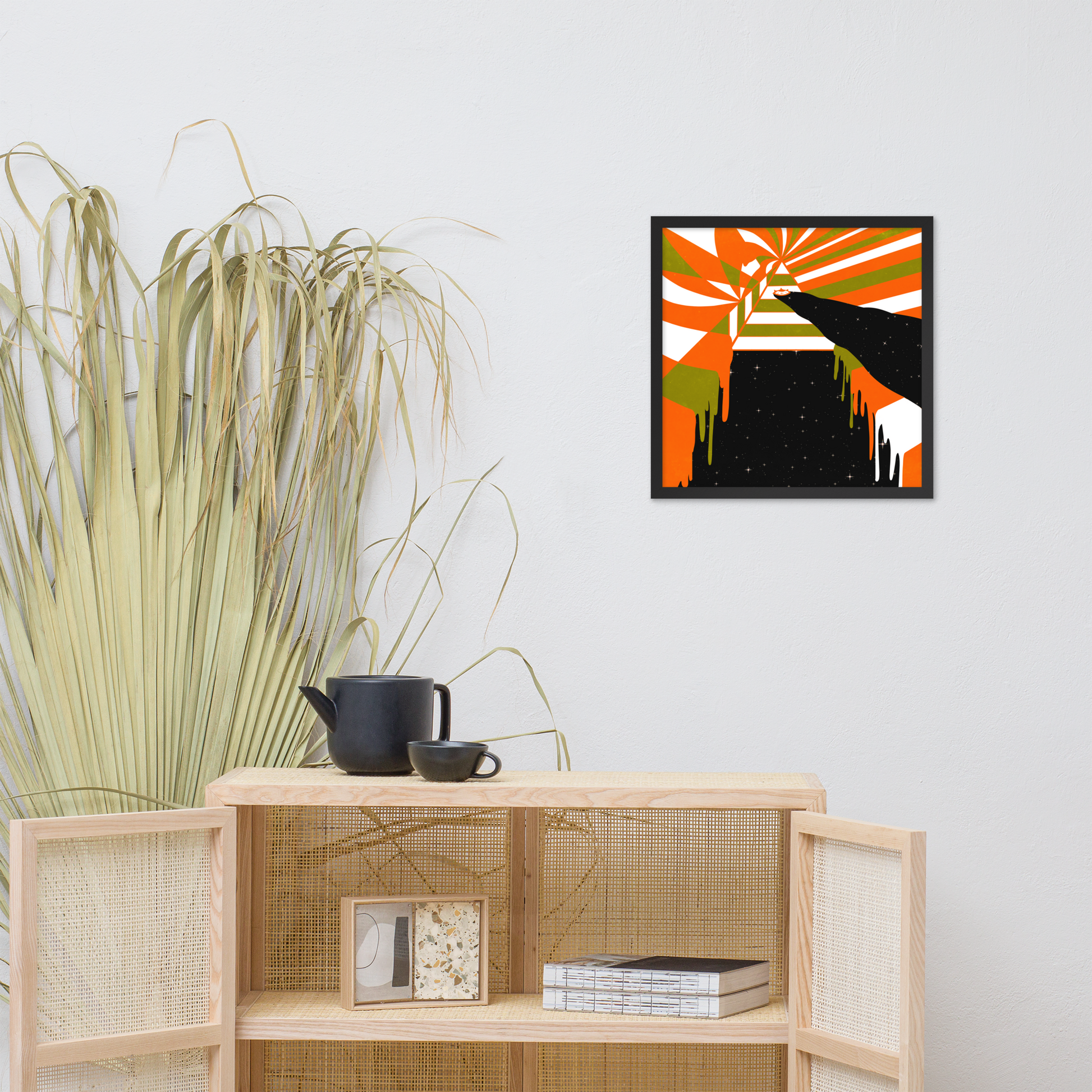 Abstract framed artwork on a wall above a wooden shelf with decorative items.