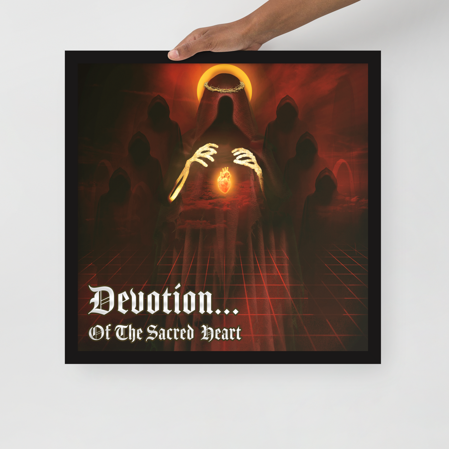 Framed artwork with a dark, mystical design and text 'Devotion... Of The Sacred Heart' held by a hand.
