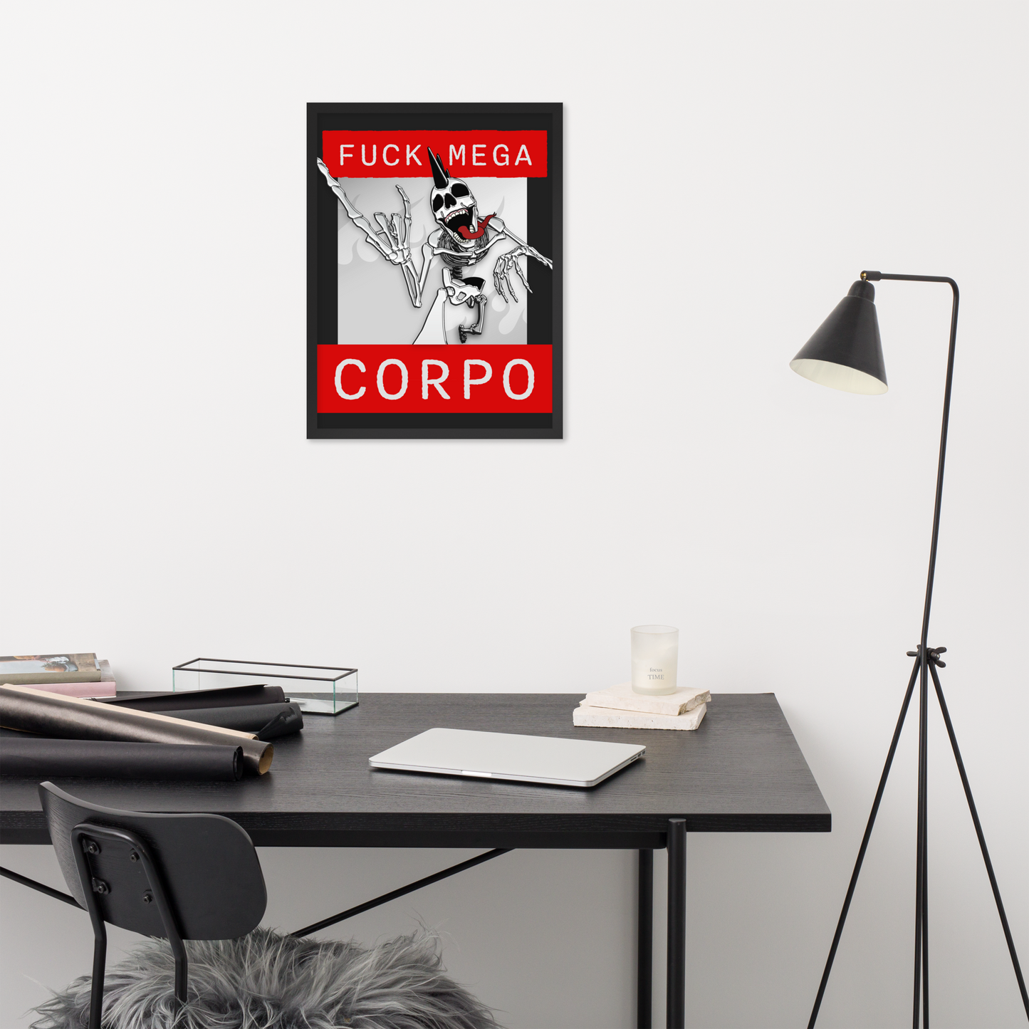 Framed 18x24 artwork of a heavy metal skeleton in front of 'FUCK MEGA CORPO' text with red, white, black, and grey coloration on a wall above a desk.
