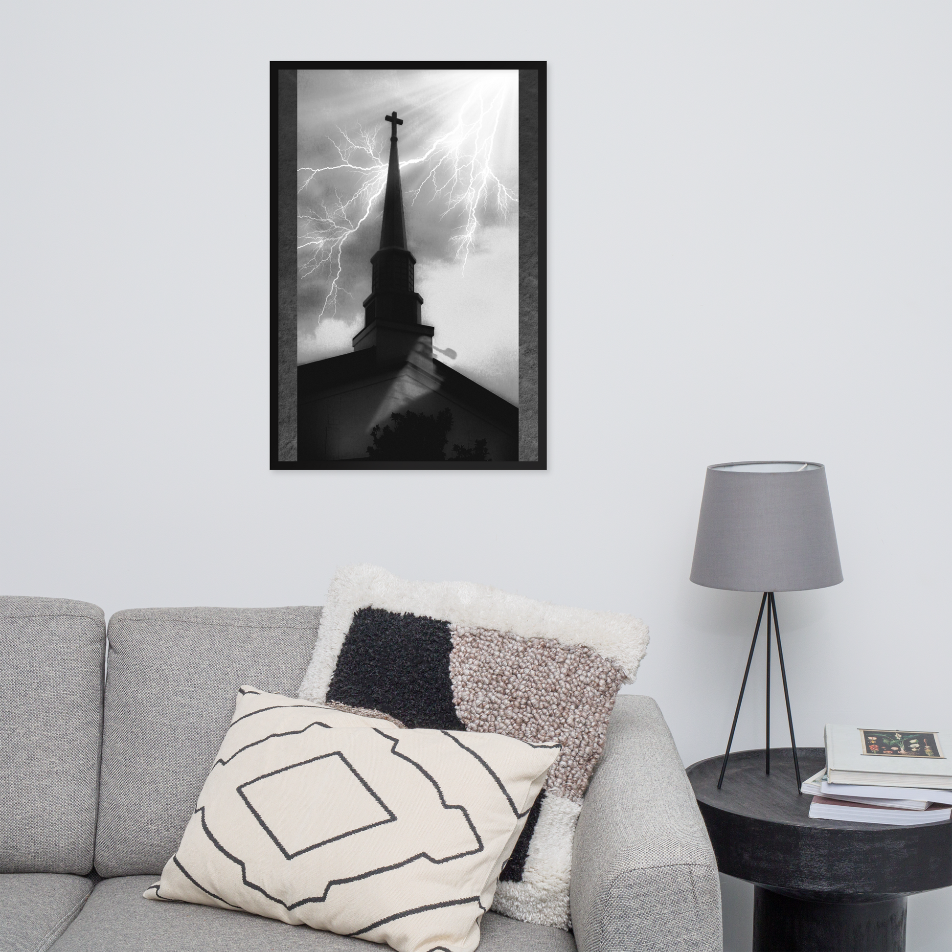 24x36 poster of a shadowy church in front of a lightning strike in grainy black and white heavy metal style over a grey living room with a couch and throw pillow