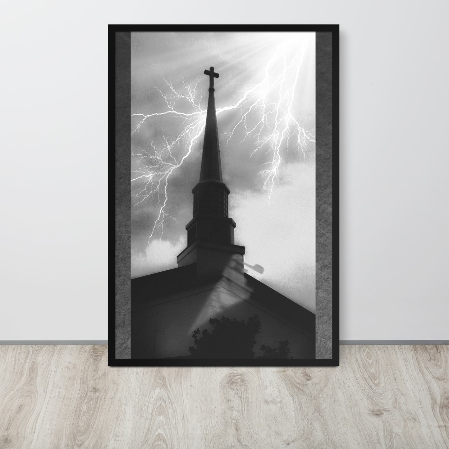 24x36 poster of a shadowy church in front of a lightning strike in grainy black and white heavy metal style leaning on a white wall