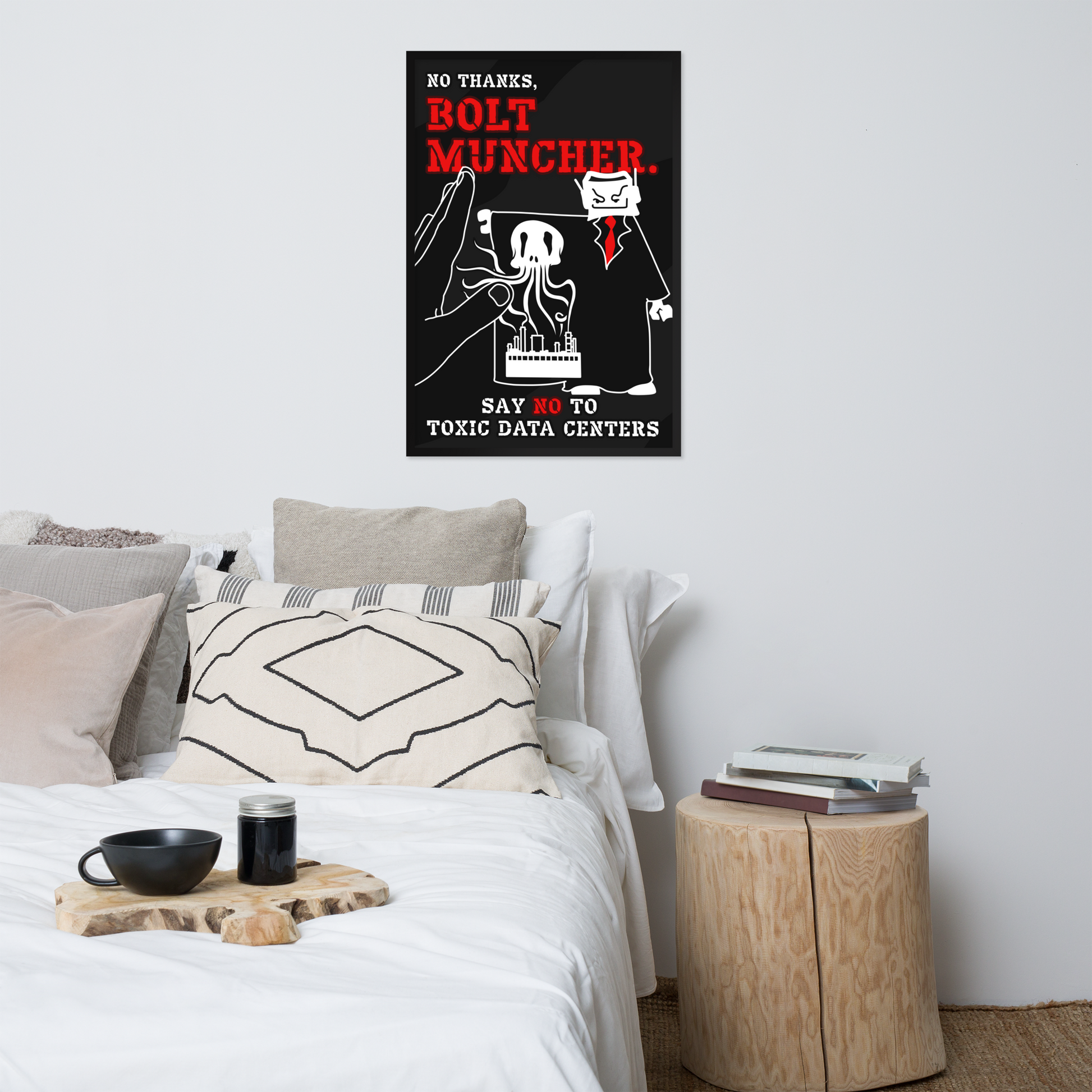A framed wall poster with a black background, red text reading 'BOLT MUNCHER,' and a white cartoon figure hangs above a bed in a styled bedroom. The room includes white bedding, neutral pillows, a small wooden side table with books, and a bowl on a tray.