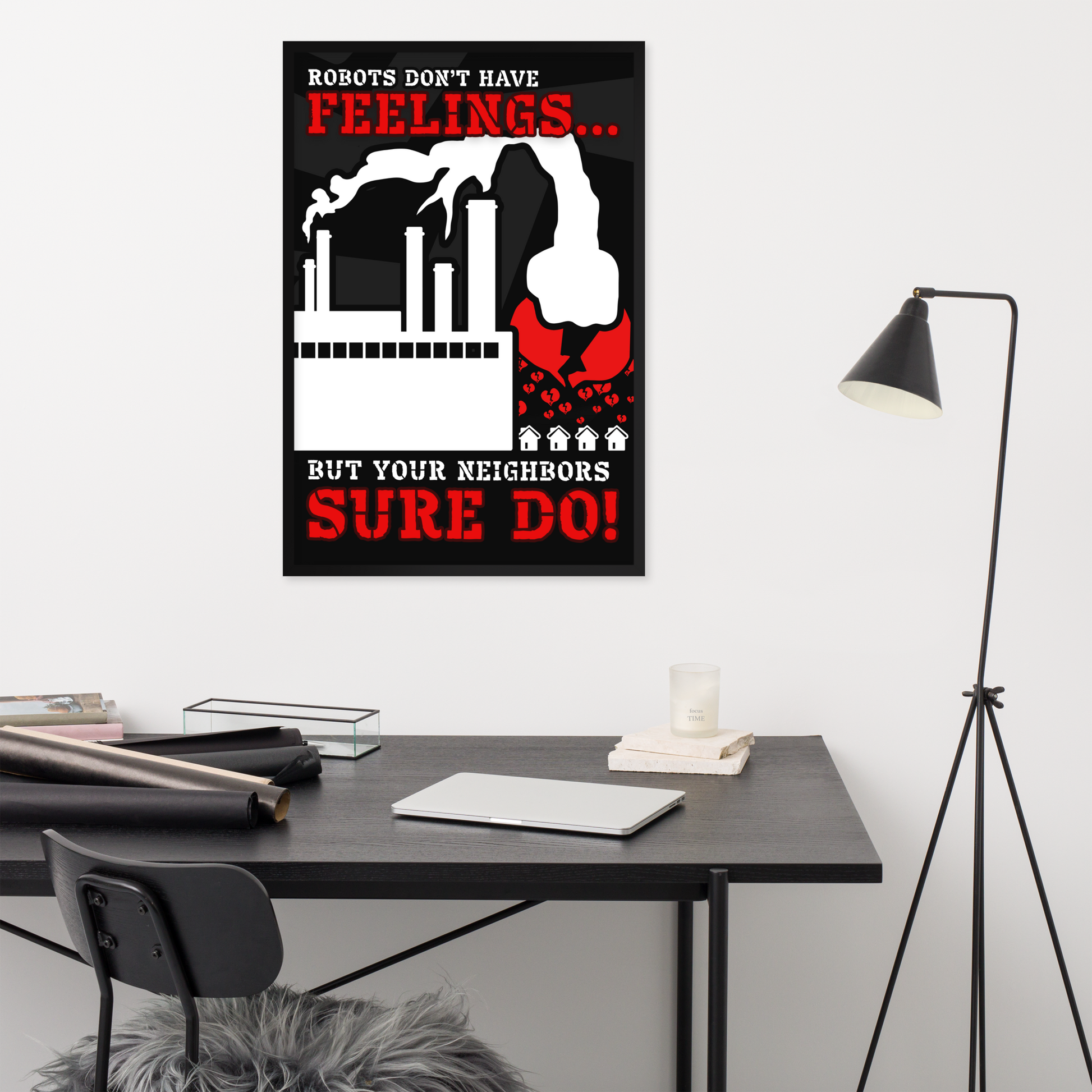 A black, white, and red wall poster hanging above a dark desk in a modern room. The poster reads, 'ROBOTS DON'T HAVE FEELINGS.