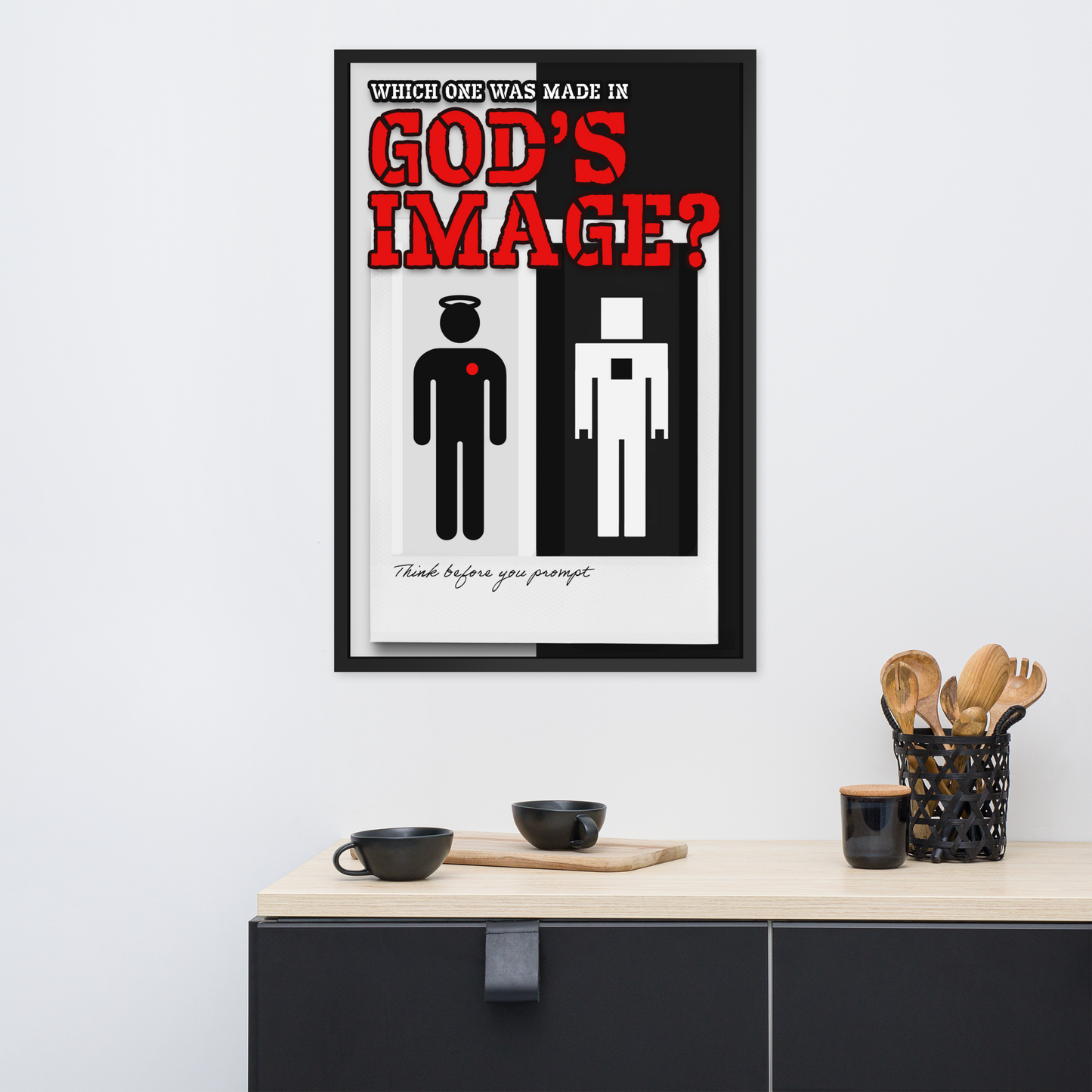 A framed minimalist art print titled 'God's Image?' hangs on a white wall above a kitchen counter with black mugs and utensils. The poster features a black and white human figure design with bold red text.