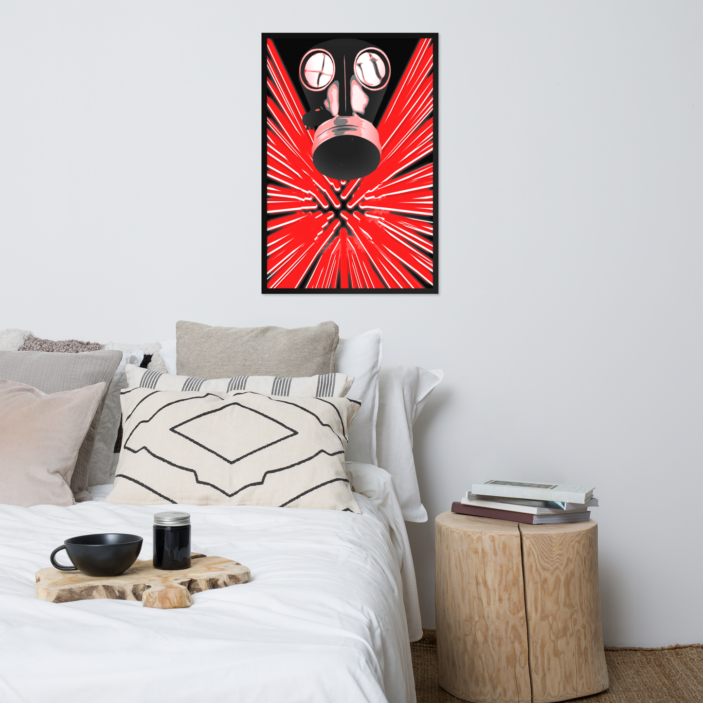 A framed wall art print featuring a black gas mask over a bright red burst pattern, displayed above a bed in a modern, neutral-toned bedroom.