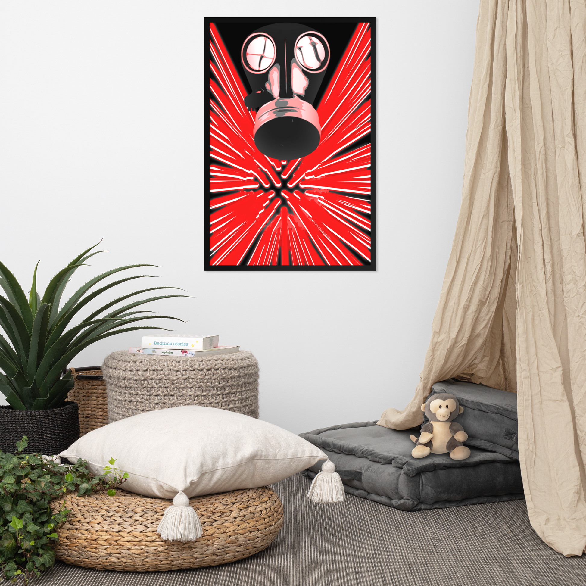 A framed wall art print featuring a black gas mask over a bright red burst pattern, displayed in a styled room with a floor cushion, pillows, a plant, and a canopy curtain.